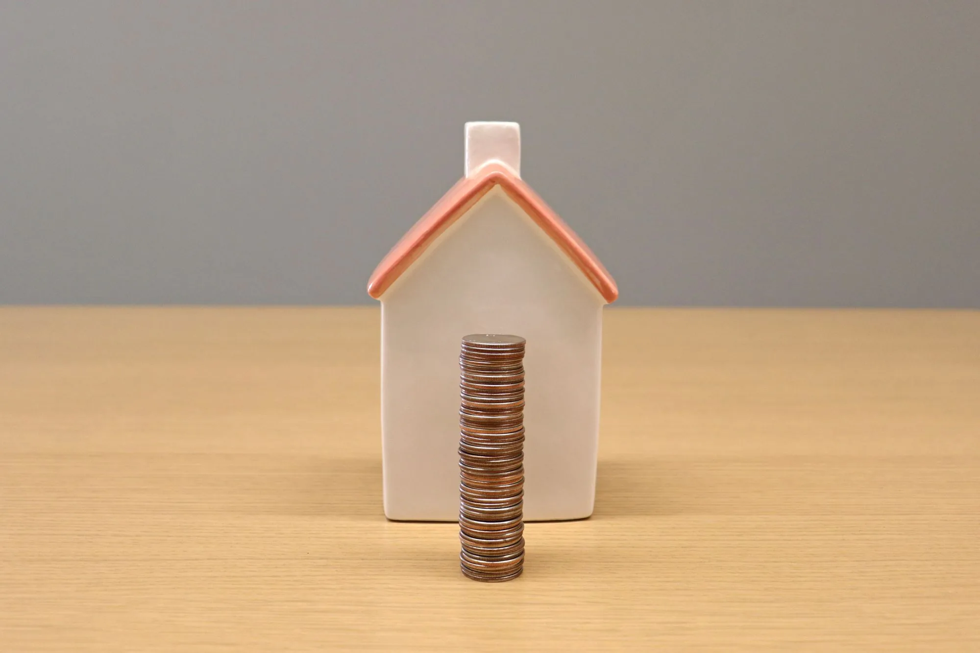 Huisje met een stapel munten ernaast
