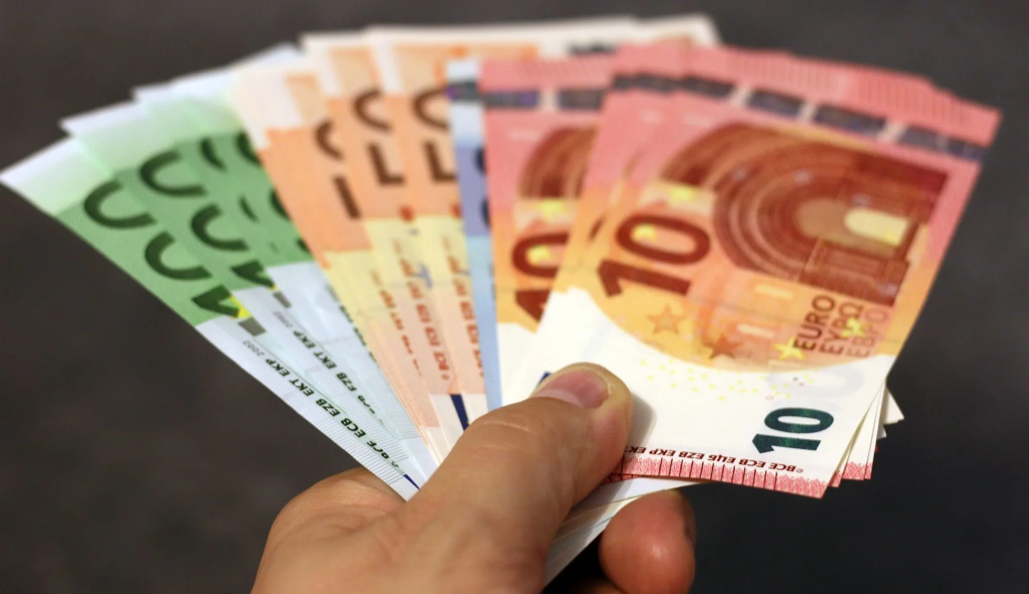 Waaier van eurobiljetten in een hand